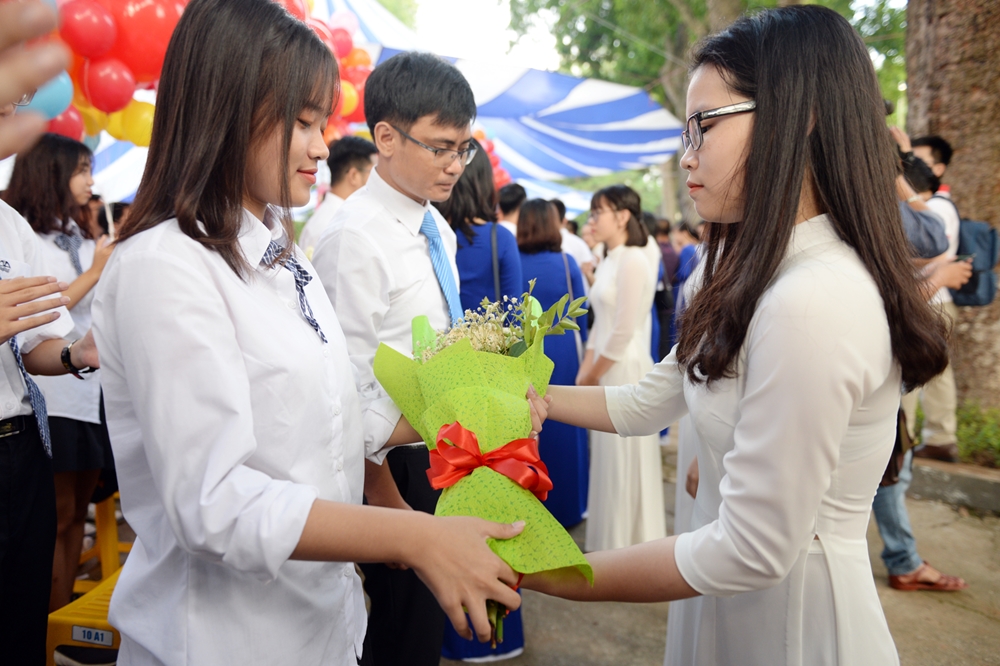 Học sinh khóa trước trao những bó hoa tươi thắm tặng các em học sinh mới.